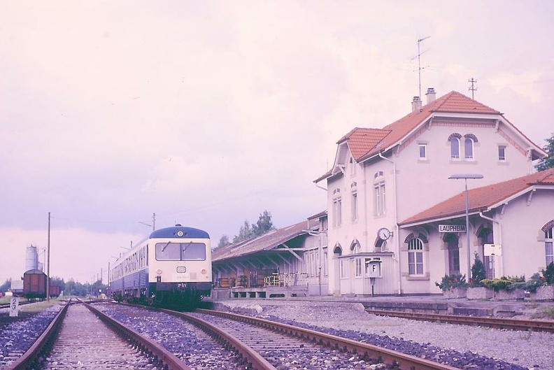 Im Rahmen der „Oberschwabenrundfahrt“ der IBSE erreichten 628 010+628 020 am 20.06.1987 den damals noch intakten Bahnhof Laupheim. Leider war eine Weiterfahrt in Richtung Schwendi damals nicht möglich, obgleich die Gleise noch nicht vollständig angebaut waren. Der Personenverkehr auf der Strecke Laupheim West – Laupheim war vier Jahre zuvor eingestellt worden. Der Bahnhof Laupheim war noch betrieblich (Fdl) und Verkehrlich (Fka, GA) besetzt. Reichlich Wechselbehälter auf der Laderampe zeugen von Stückgutverkehr, weitere Wagen stehen im Bahnhof zur Be- oder Entladung bereit, es sind mehrere Gleise vorhanden. Im Jahre 2000 wurde der Personenverkehr nach Laupheim Stadt (die Umbenennung erfolgte gleichzeitig mit Wiederaufnahme des PV) wieder aufgenommen. Das Empfangsgebäude ist mittlerweile arg herunter gekommen, der Güterschuppen abgerissen. Der heutige Bahnsteig befindet sich nördlich der Halteposition des Sonderzuges. p000637.jpg